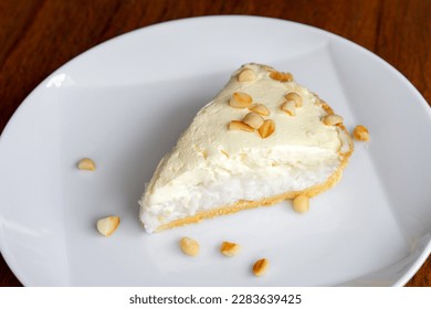 Coconut Cream Pie in the white dish on the wood table that topping with macademia. Shooting in the sunlight. - Powered by Shutterstock