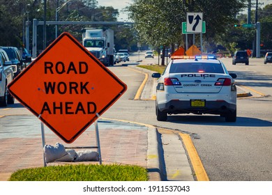 Coconut Creek, Florida, USA - February 05, 2021: Police Car Staying On The Road With Lights For Traffic Control In Road Work Zone.