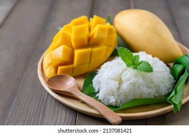 Coconut Flavored Sticky Rice with Ripe Mango on wood dish, Popular Thai desserts on summer.