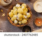 Coconut Ladoo or Nariyal Ladoo  Sweet made with coconut served in a cooper plate on Dark Background.