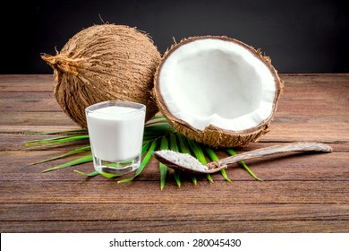 Coconut And Coconut Milk In Glass On Wooden Table