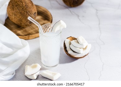 Coconut Milk In A Glass And Pieces Of Tropical Fruit On The Table. Natural Source Of Antioxidants, Plant Alternative