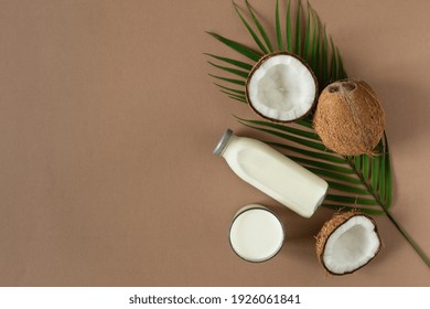 Coconut  Milk With Coconut Halves Top View On Brown Background. Coconut Vegan Milk.