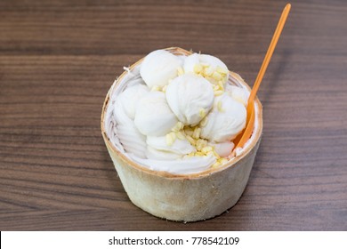Coconut Milk Ice Cream in the coconut shell on wooden table background. Thai dessert concept.