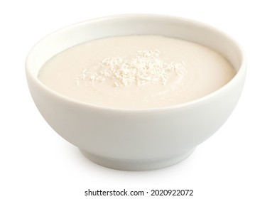 Coconut Milk In White Ceramic Bowl Topped With Desiccated Coconut Isolated On White.