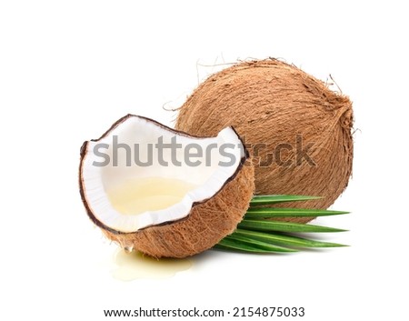 Coconut oil dripping from coconut fruits cut in half isolated on white background.
