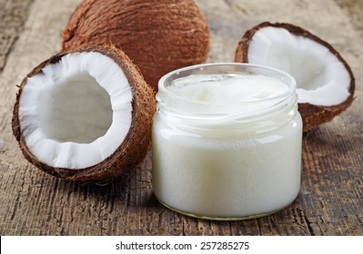 coconut oil and fresh coconuts on old wooden table - Shutterstock ID 257285275