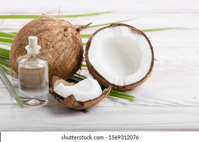 Coconut Oil In Glass Jar And Shell Pieces On White Wooden Table