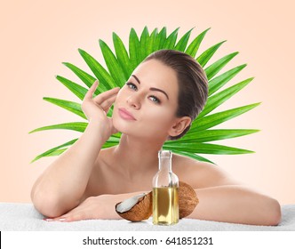 Coconut Oil For Skin. Young Woman And Cosmetic On Color Background