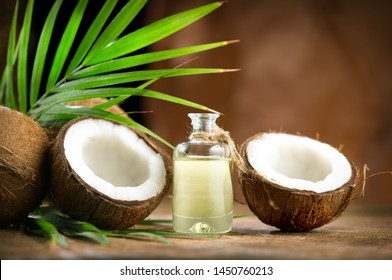 椰子棕榈油装在瓶子里，棕色背景上有椰子和绿色的棕榈树叶。可可坚果特写。健康食品，皮肤护理概念。护肤护理。纯素食品
