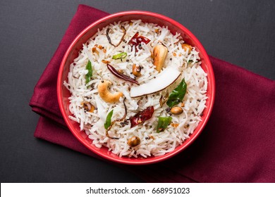 Coconut Rice - South Indian recipe using leftover cooked Basmati rice, served in a red bowl over moody background, selective focus - Powered by Shutterstock