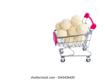 coconut round candies in a mini shopping basket, isolate on a white background. Supermarket shopping concept. full cart of sweets. High quality photo
