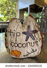 Coconut Tip Jar Sitting On A Restaurant Counter