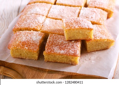 Coconut Tray Bake, Sliced On Wooden Board