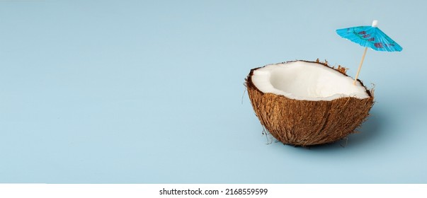 Coconut With An Umbrella On A Background Of Blue Sky. High Quality Photo