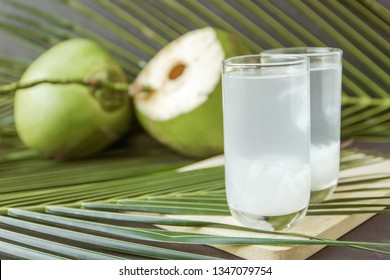 coconut water in glass on wooden board for drink.
