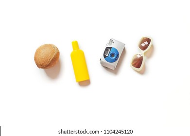 Coconut, yellow sunscreen bottle, camera and sunglasses on a white background. Flat lay photo summer beach essentials. Minimal photography