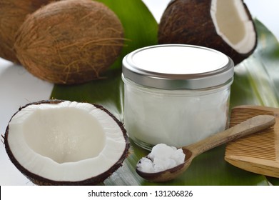 Coconuts and organic coconut oil in a glass jar on white background. Hair treatment.