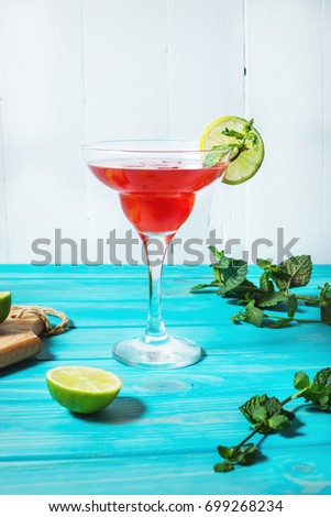 Coctail margarita with lime on blue wood background.
