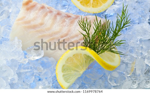 Cod fish fillets on\
ice with fresh Lemon 