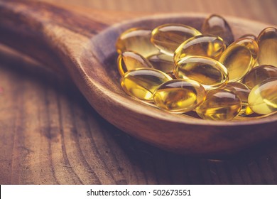 Cod Liver Oil Omega 3 Gel Capsules Isolated On Wooden Background. Vitamin D Capsuls. Dietary Supplement