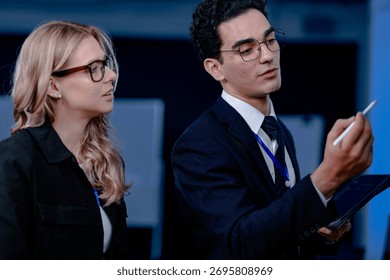 Code breakthrough achieved. Smiling senior developer points to a successful code segment on screen, sharing the solution with his colleague during a late night pair programming session.