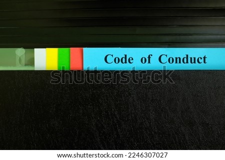 Code of conduct file record in black binder folder. Company code of conduct ethical standard concept.