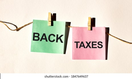 code of conduct text words BACK TAXES on yellow sticker note on white wall or table.