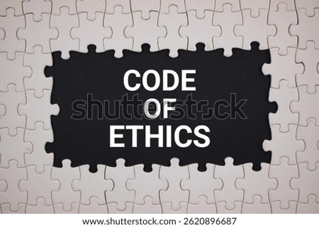 code of ethics concept. white puzzle with black background with 'CODE OF ETHNIC' written on it, top view
