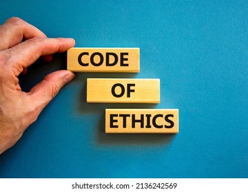 Code of ethics symbol. Concept words Code of ethics on wooden blocks on a beautiful blue table blue background. Businessman hand. Business and code of ethics concept. Copy space. - Shutterstock ID 2136242569