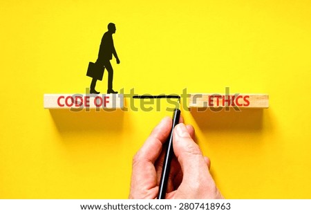 Code of ethics words symbol. Concept words Code of ethics on beautiful wooden blocks. Beautiful yellow background. Businessman hand. Business Code of ethics concept. Copy space.
