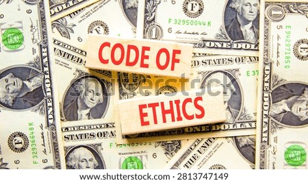 Code of ethics words symbol. Concept words Code of ethics on beautiful wooden blocks. Beautiful dollar bills background. Dollar bills. Business Code of ethics concept. Copy space.