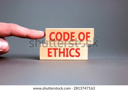 Code of ethics words symbol. Concept words Code of ethics on beautiful wooden blocks. Beautiful grey background. Businessman hand. Business Code of ethics concept. Copy space.