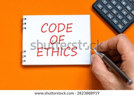 Code of ethics words symbol. Concept words Code of ethics on beautiful white note. Beautiful orange background. Businessman hand. Business Code of ethics concept. Copy space.