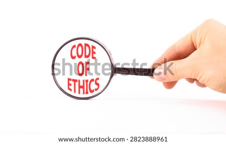 Code of ethics words symbol. Concept words Code of ethics on beautiful magnifying glass. Beautiful white background. Businessman hand. Business Code of ethics concept. Copy space.