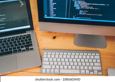 Code of program on monitor screen. Monitor screen showing code with mouse, keyboard on wooden table