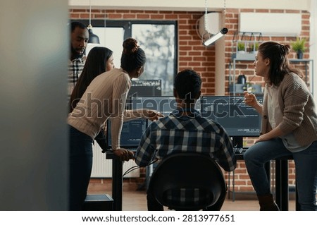 Coder team discusses source code compiling discovers errors and asks the rest of the team for explanations at a desk with active screens, highlighting debugging pressure, source code review.