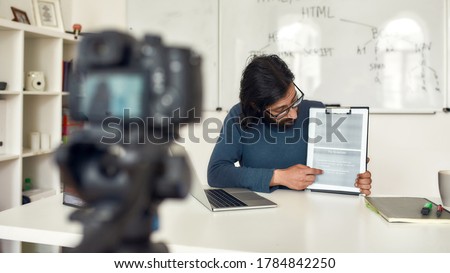 Coding Classes Online. Professional programming male tutor recording video blog about HTML on professional digital equipment, giving online lesson. Focus on teacher. E-learning. Distance education