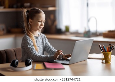Coding For Kids. Cute Little Girl Using Laptop While Sitting At Desk At Home, Smiling Preteen Female Child Attending Programming Courses, Looking At Computer Screen And Typing On Keyboard - Powered by Shutterstock