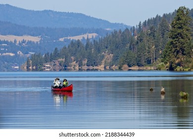 Coeur D'Alene, Idaho  USA - 08-08-2022: An Editorial Photo Of A Mature Couple Paddling The Canoe On Coeur D'Alene Lake In North Idaho.