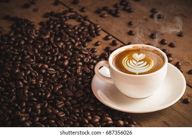 Cofee Cup Espresso And Coffee Beans With Hot Latte Art On Wooden Background. Side View With Copy Space For Your Text