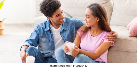 Cofee Time. Black Millenial Couple Holding Cups And Having Fun Together At Home