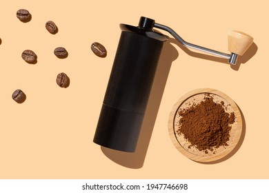 Coffee bean grinding process concept, beans, manual coffee grinder, ground beans on a beige background, hard trend light
