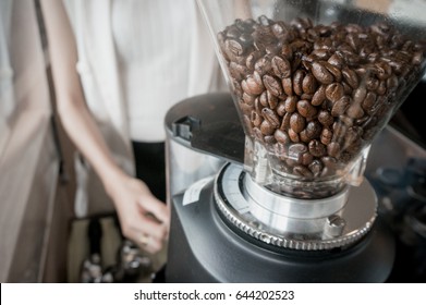 Kaffeebohnen in Kaffeemaschine im Kaffeehaus mit Barista