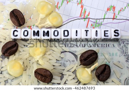 Coffee bean, rice, corn and letter cube on dollar and candle stick chart background. Conceptual image of commodity trading.