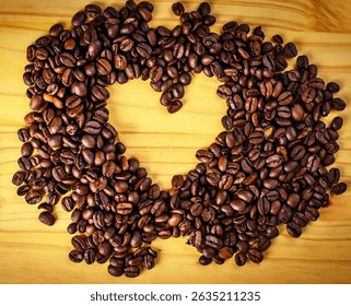 Coffee beans arranged in heart shape on wooden surface