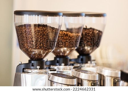 Coffee beans in bean hopper, part of coffee machine in a coffee shop.