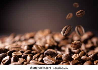 Coffee beans at the fabrique. Coffee beans fall on the table. Background made of falling down fresh coffee beans with copy space - Powered by Shutterstock