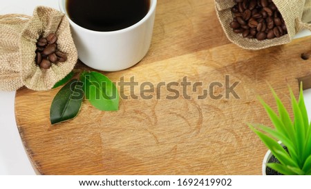 Coffee beans falling on wooden board. Close up.
