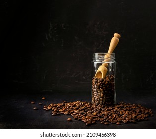 Coffee beans in a glass jar. roasted beans . Black Americano coffee.  Coffee shop concept, coffee lovers and connoisseurs. jar on a dark background. Morning.